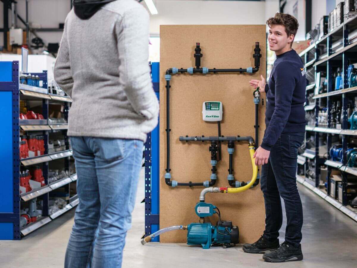 Wildkamp medewerker helpt klant in vestiging met beregeningsinstallatie