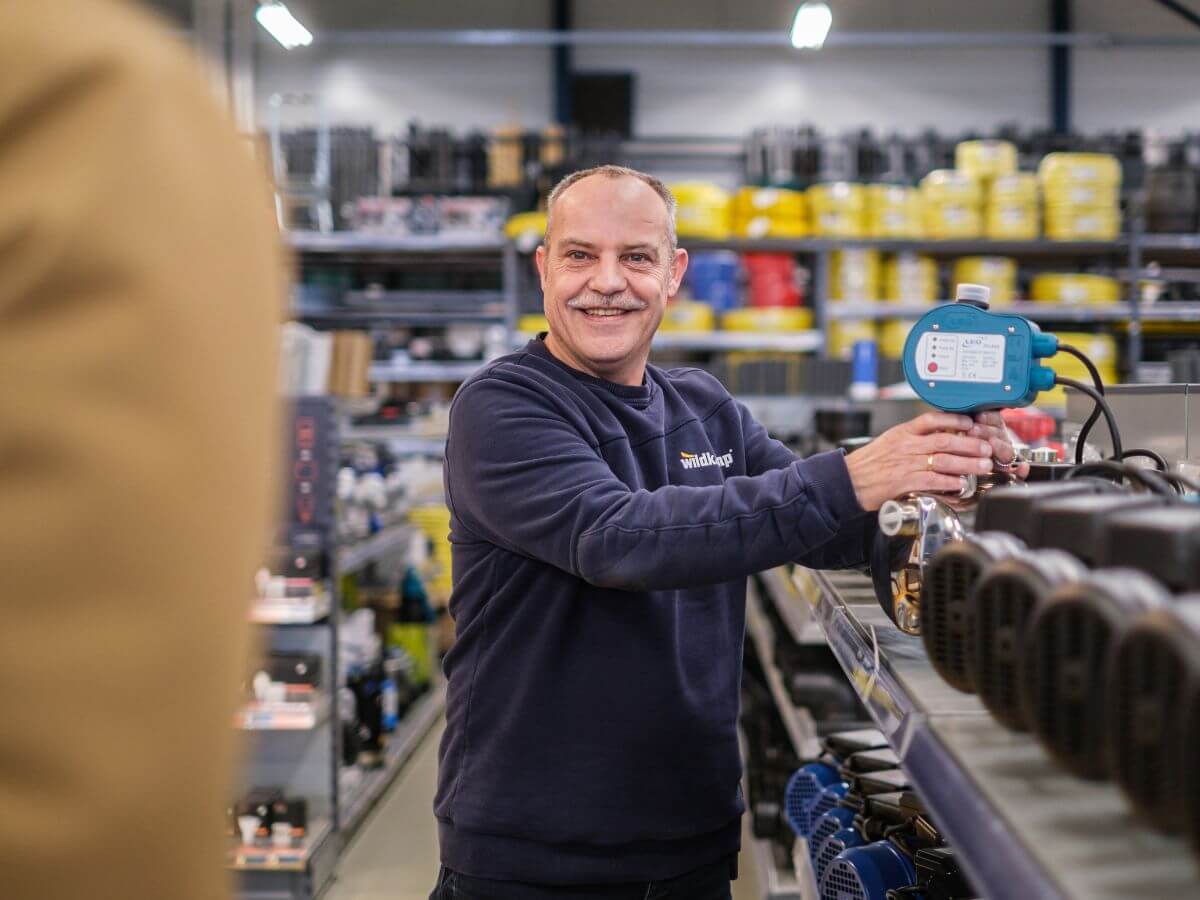 Wildkamp medewerker helpt klant in vestiging met pomp