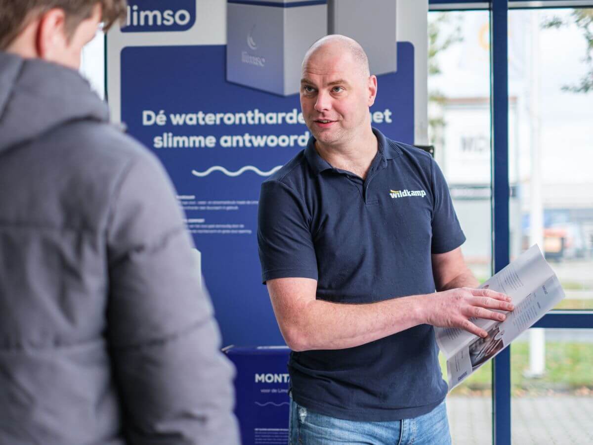 Wildkamp medewerker helpt klant in vestiging met waterontharder