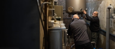 Monteurs installeren een RVS drukvat voor een waterinstallatie