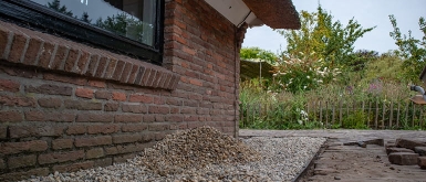 woonboerderij met grind en groene tuin